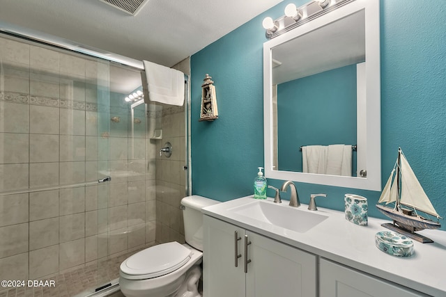 bathroom featuring toilet, vanity, a textured ceiling, and walk in shower