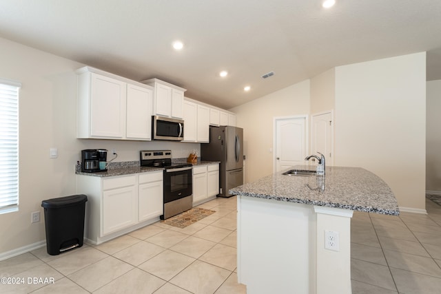 kitchen featuring a center island with sink, vaulted ceiling, white cabinets, sink, and appliances with stainless steel finishes