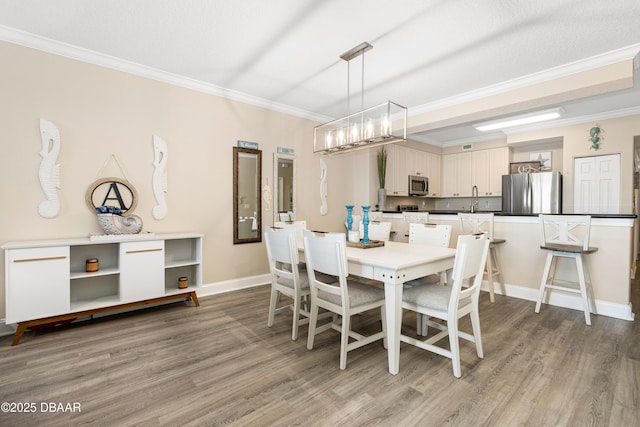 dining area with crown molding, sink, a textured ceiling, and hardwood / wood-style flooring