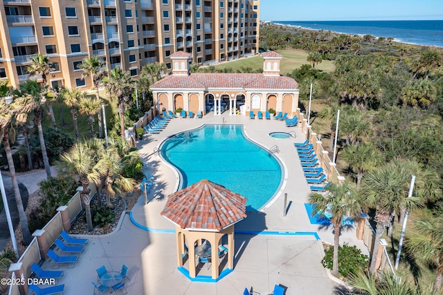 view of swimming pool featuring a water view and a patio area