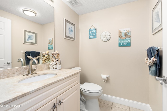 bathroom featuring tile patterned flooring, vanity, toilet, and a textured ceiling