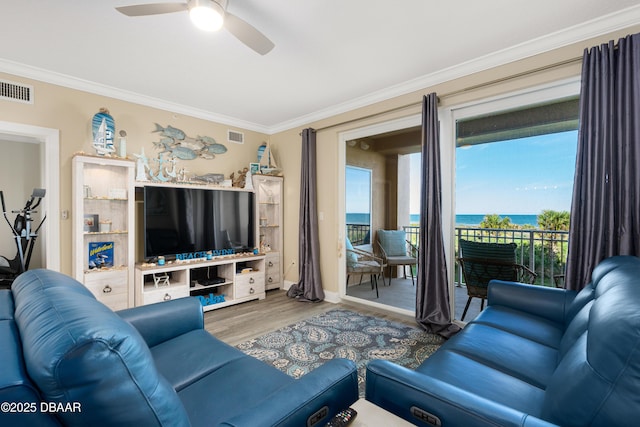 living room with ceiling fan, wood-type flooring, and crown molding