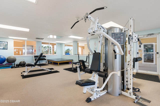 gym with carpet flooring and a textured ceiling