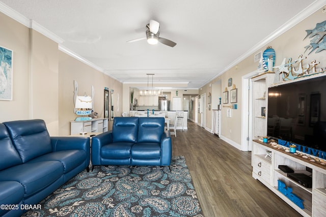 living room with dark hardwood / wood-style flooring, ceiling fan, and crown molding