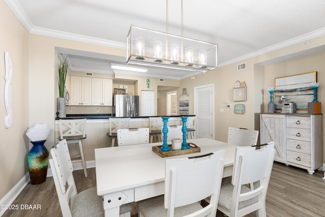 dining space featuring hardwood / wood-style floors, crown molding, and a textured ceiling