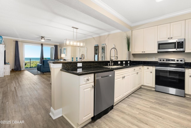 kitchen featuring kitchen peninsula, stainless steel appliances, hanging light fixtures, and sink