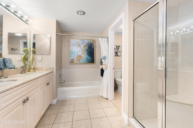 full bathroom with vanity, tile patterned floors, separate shower and tub, toilet, and a textured ceiling