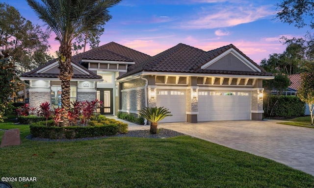 view of front facade with a lawn, a garage, and french doors