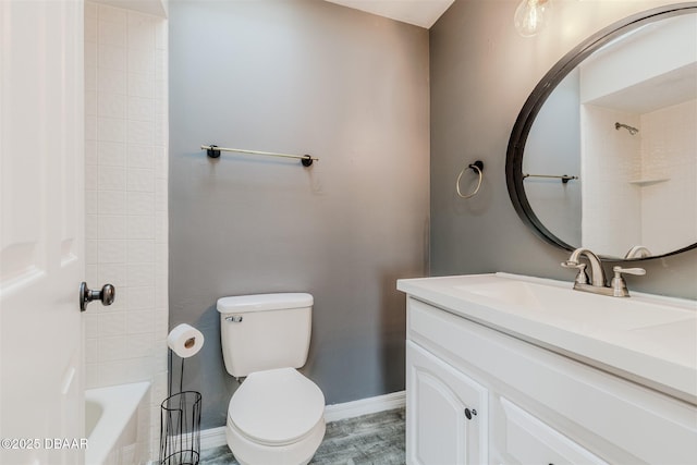 full bathroom featuring vanity, tiled shower / bath, and toilet