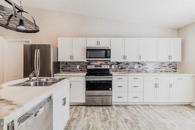 kitchen featuring sink, white cabinetry, light hardwood / wood-style flooring, appliances with stainless steel finishes, and decorative backsplash