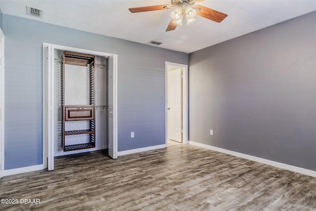 unfurnished bedroom featuring wood-type flooring, a closet, and ceiling fan