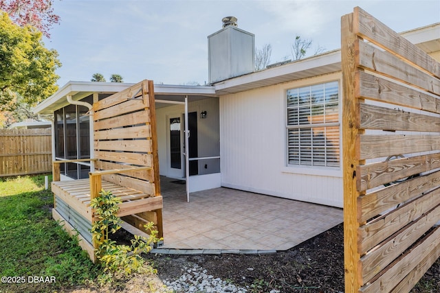 rear view of property featuring a sunroom and a patio