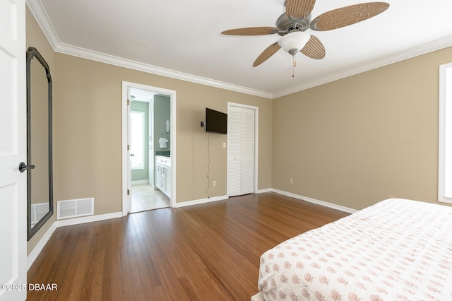 unfurnished bedroom featuring crown molding, ensuite bath, ceiling fan, hardwood / wood-style floors, and a closet