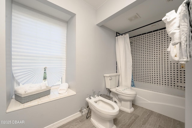 bathroom featuring shower / bath combo, a bidet, and toilet