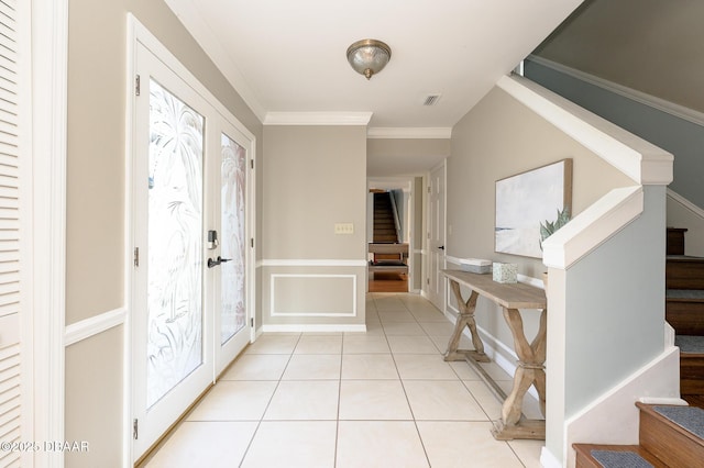 foyer entrance with crown molding, a wealth of natural light, and light tile patterned floors