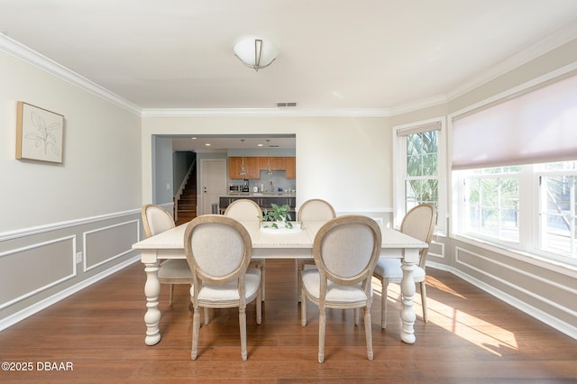 dining room featuring ornamental molding and dark hardwood / wood-style flooring