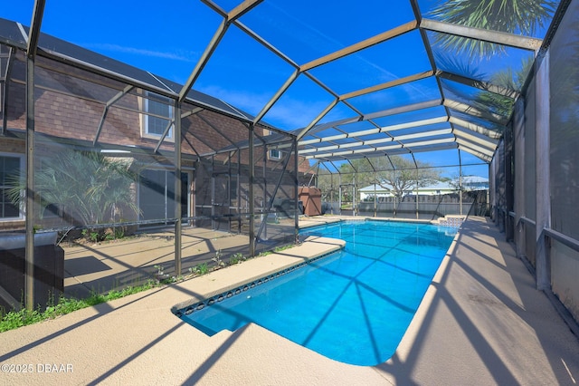 view of swimming pool with a patio area and glass enclosure