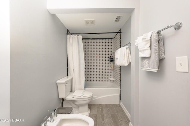 full bathroom featuring shower / tub combo with curtain, toilet, sink, and a bidet