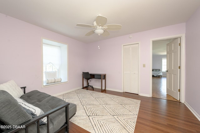 living area featuring light hardwood / wood-style floors and ceiling fan