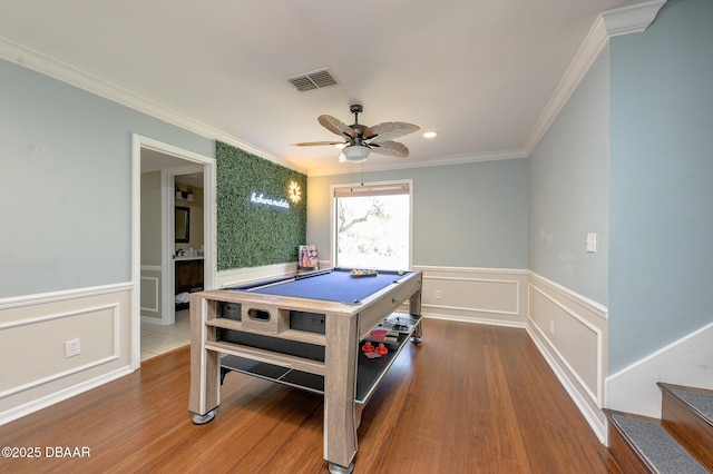 recreation room with ceiling fan, ornamental molding, and wood-type flooring