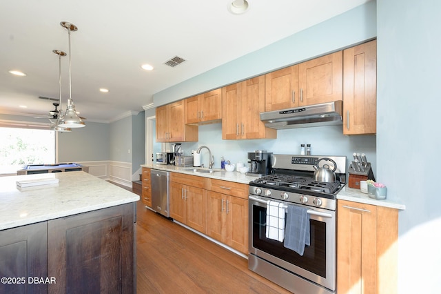 kitchen featuring sink, decorative light fixtures, appliances with stainless steel finishes, dark hardwood / wood-style flooring, and light stone countertops