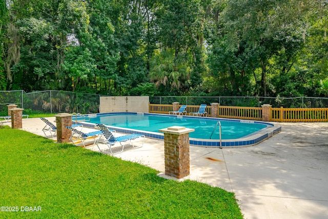 view of pool featuring a lawn and a patio area