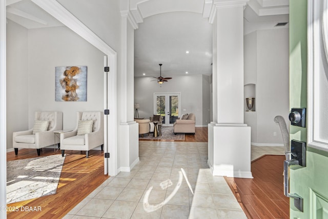 tiled foyer with ornate columns, ceiling fan, and french doors