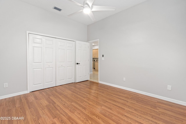 unfurnished bedroom with ceiling fan, a closet, and light wood-type flooring