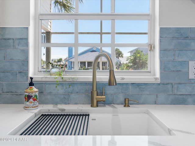 interior details featuring light stone counters and a sink