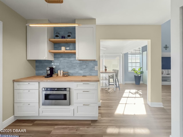 kitchen featuring open shelves, butcher block counters, decorative backsplash, white cabinets, and oven