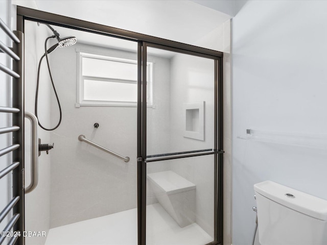 bathroom with a shower stall and toilet