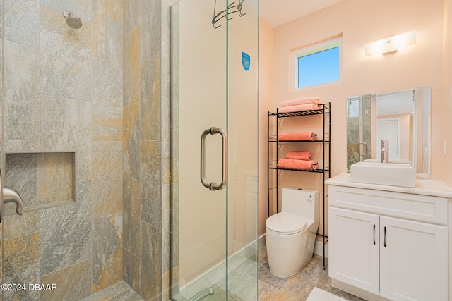 bathroom featuring toilet, vanity, and a shower with shower door