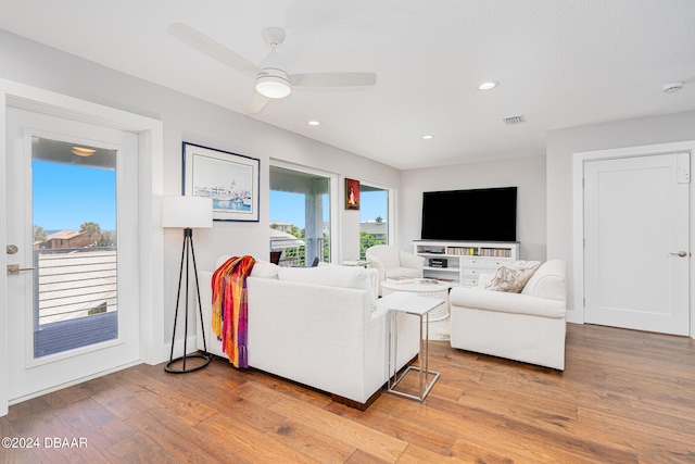 living room featuring wood-type flooring and ceiling fan