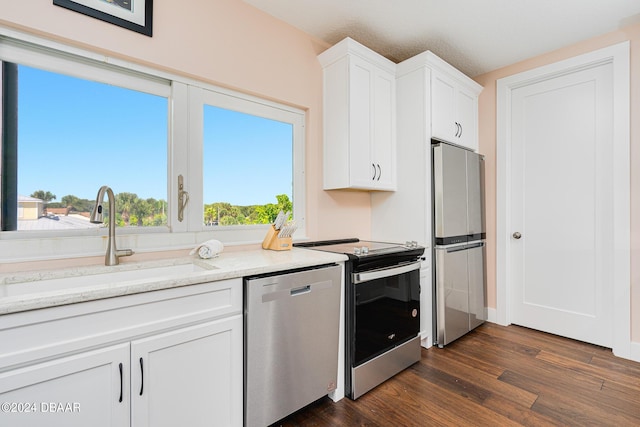 4727 Riverglen Blvd, Ponce Inlet, FL 32127 - kitchen featuring appliances with stainless steel finishes, a sink, dark wood-style flooring, white cabinets, and light stone countertops