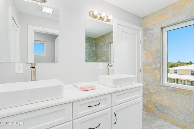 bathroom with tile walls, vanity, and plenty of natural light