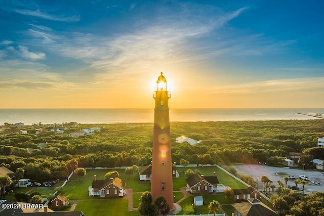 aerial view at dusk featuring a water view