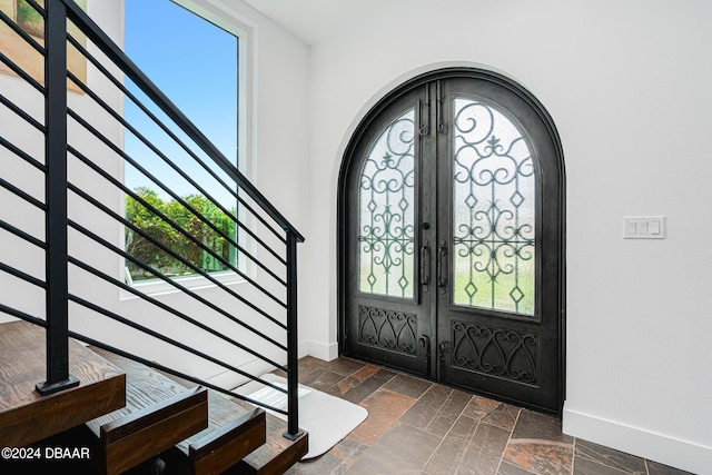 4727 Riverglen Blvd, Ponce Inlet, FL 32127 - entryway featuring french doors, stone tile flooring, and baseboards