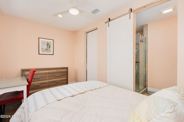 bedroom featuring a barn door, ceiling fan, and a closet