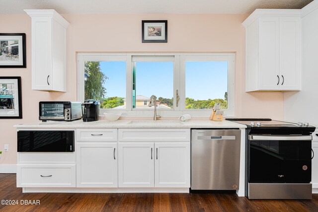 kitchen featuring stainless steel appliances, white cabinetry, sink, and dark hardwood / wood-style flooring