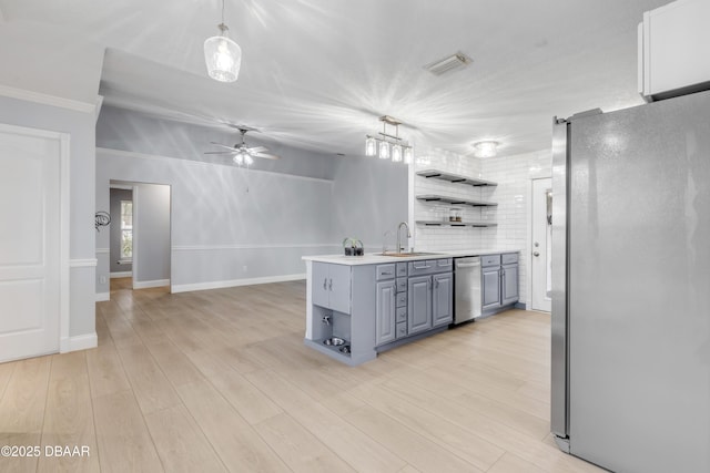 kitchen featuring light hardwood / wood-style floors, gray cabinetry, stainless steel refrigerator, pendant lighting, and sink