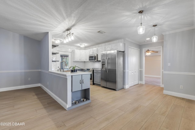 kitchen featuring backsplash, kitchen peninsula, hanging light fixtures, appliances with stainless steel finishes, and white cabinets