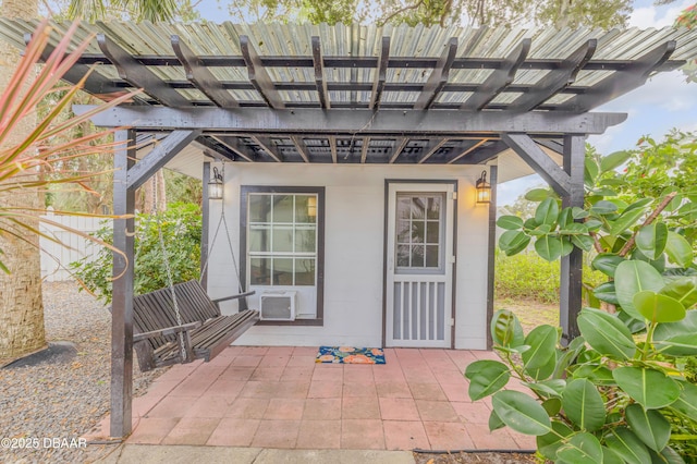 doorway to property with a pergola, a patio area, and cooling unit