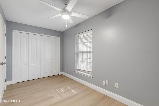 unfurnished bedroom with ceiling fan, a closet, and light hardwood / wood-style flooring