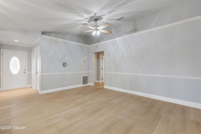 spare room with lofted ceiling, ceiling fan, light wood-type flooring, and a textured ceiling