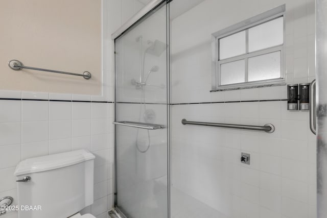 bathroom featuring tile walls, an enclosed shower, and toilet