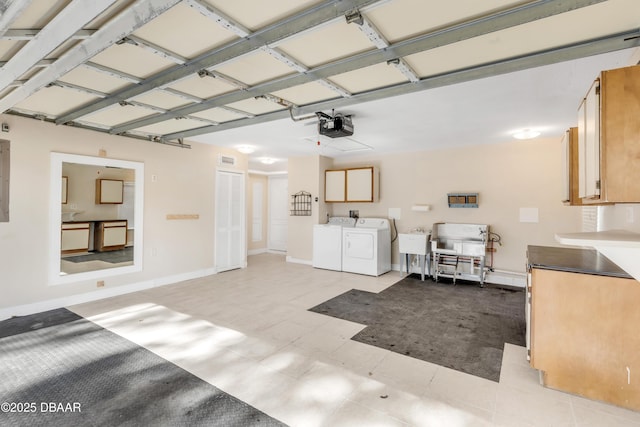 garage with sink, a garage door opener, and washing machine and clothes dryer