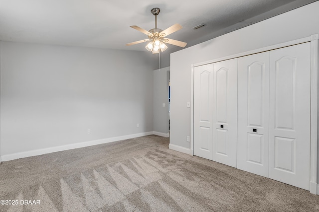 unfurnished bedroom with ceiling fan, light colored carpet, and a closet