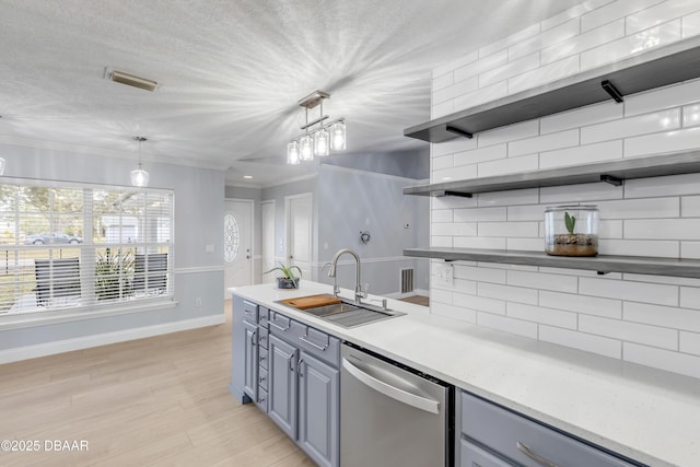 kitchen featuring pendant lighting, sink, backsplash, stainless steel dishwasher, and crown molding