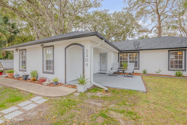 ranch-style home featuring a front lawn and a patio