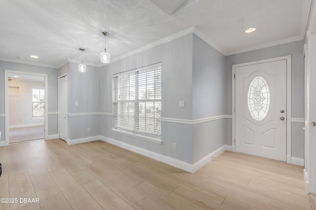 foyer entrance featuring light hardwood / wood-style flooring, crown molding, and a healthy amount of sunlight